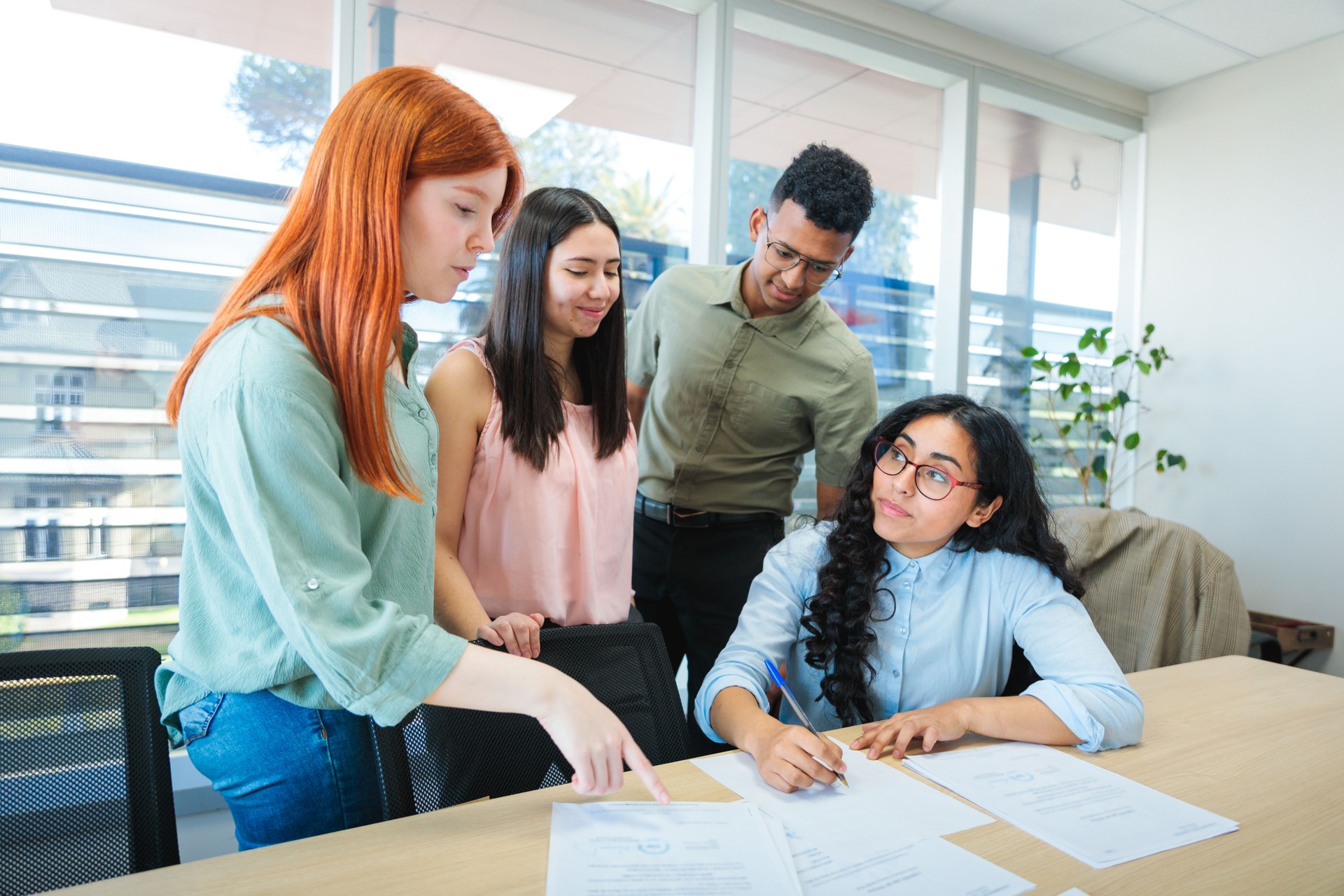 Young professionals collaborating in a bright co-working space, focused on teamwork