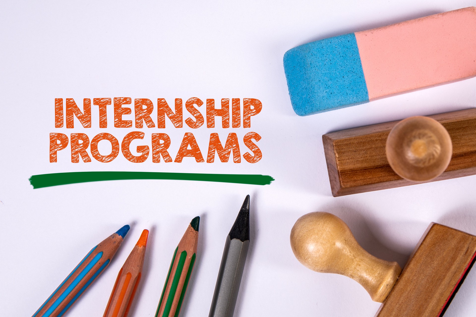 Internship Programs. Colored pencils, stamps and eraser on a white background