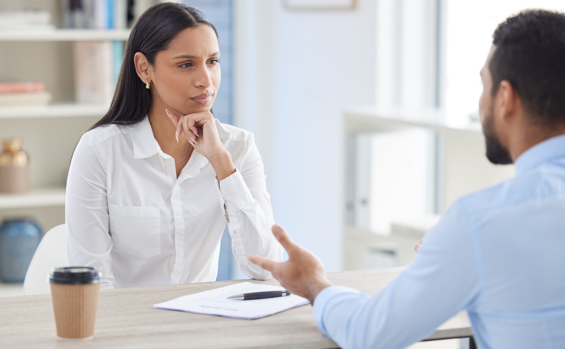 Mixed race hiring manger in interview with businessman. CEO with resume and cv of candidate looking for job opening, vacancy, office opportunity. Applicant sitting and explaining experience to hr boss