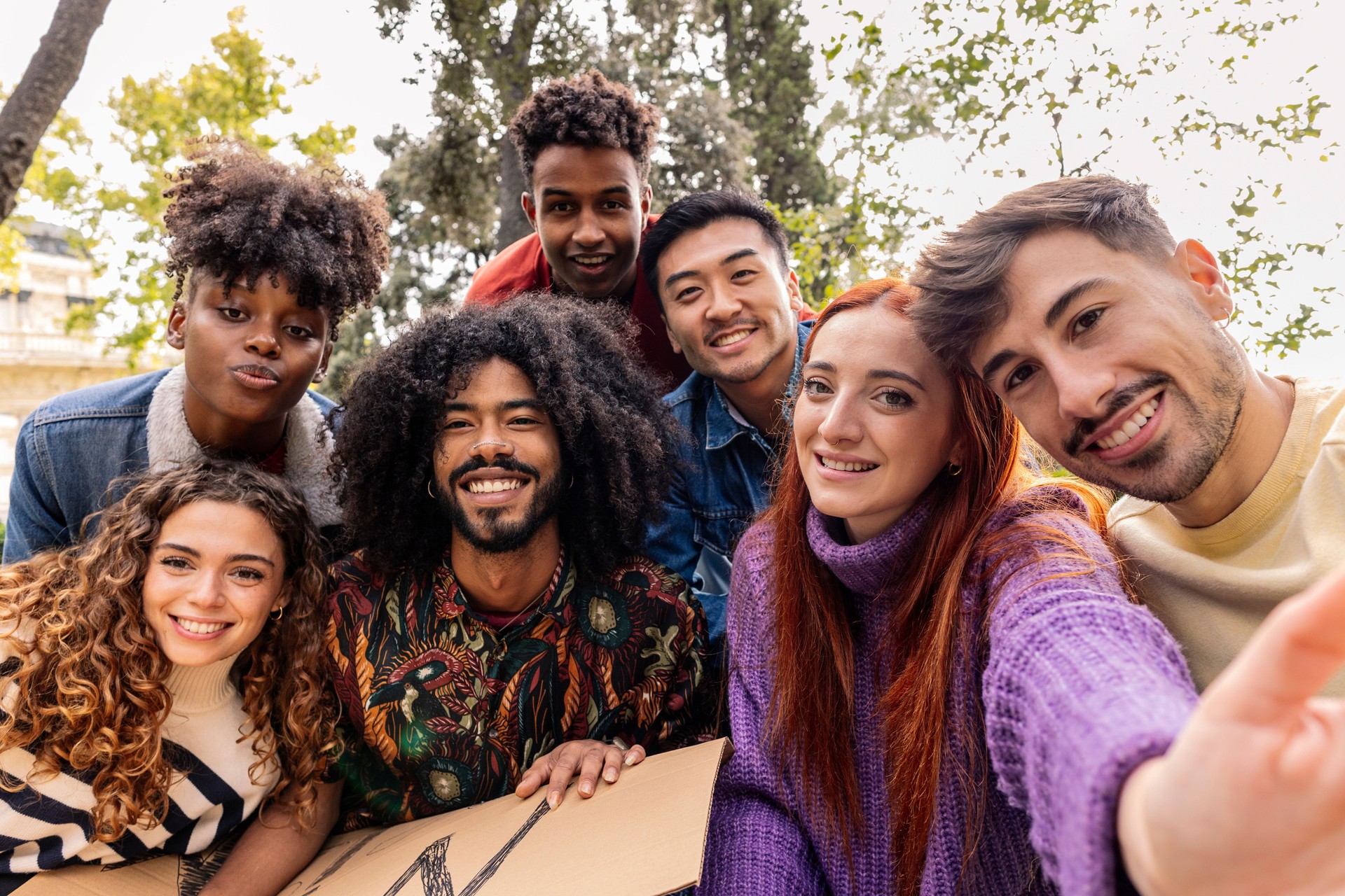 selfie of group of multiethnic friends with banners for peace and against racism